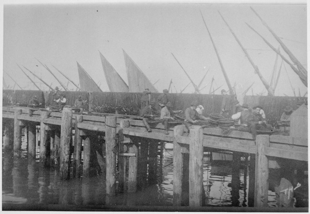 Italian fishermen mending nets, historical photograph